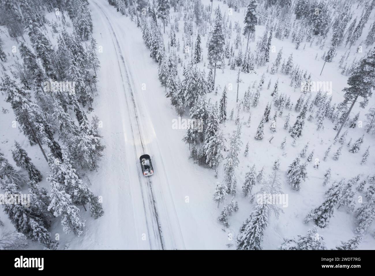 Aerial shot of a car crossing the boreal forest covered with snow, Akaslompolo, Finnish Lapalnd, Finland, Scandinavia, Europe Stock Photo