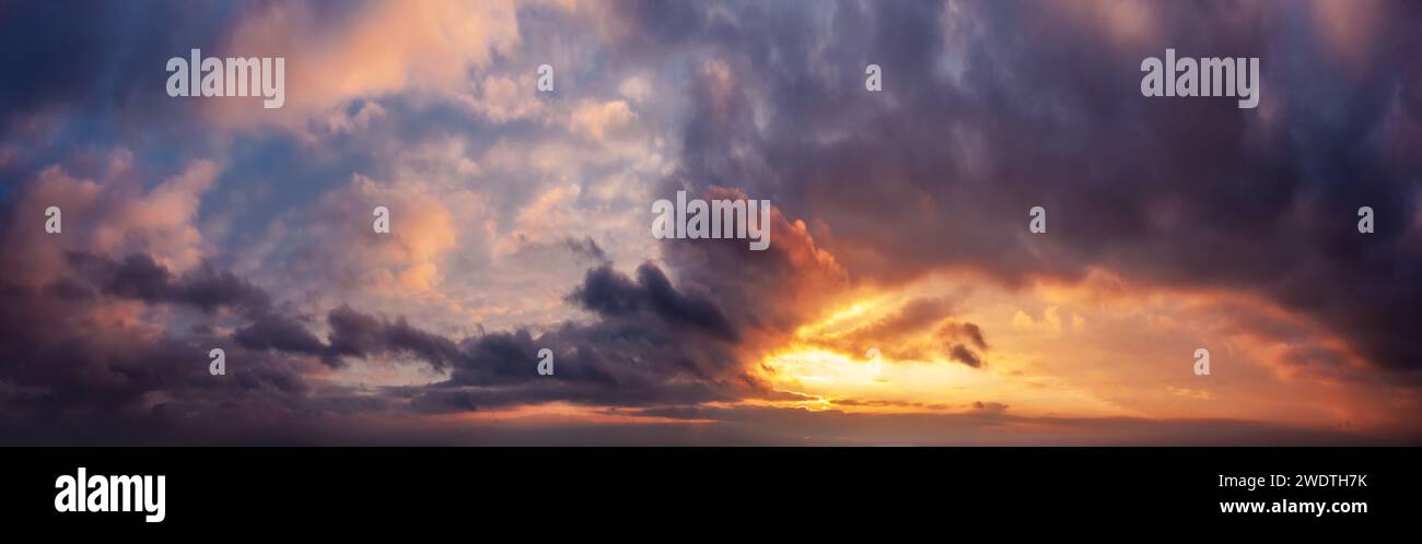 Dramatic sunset sky panorama during golden hour. Stock Photo