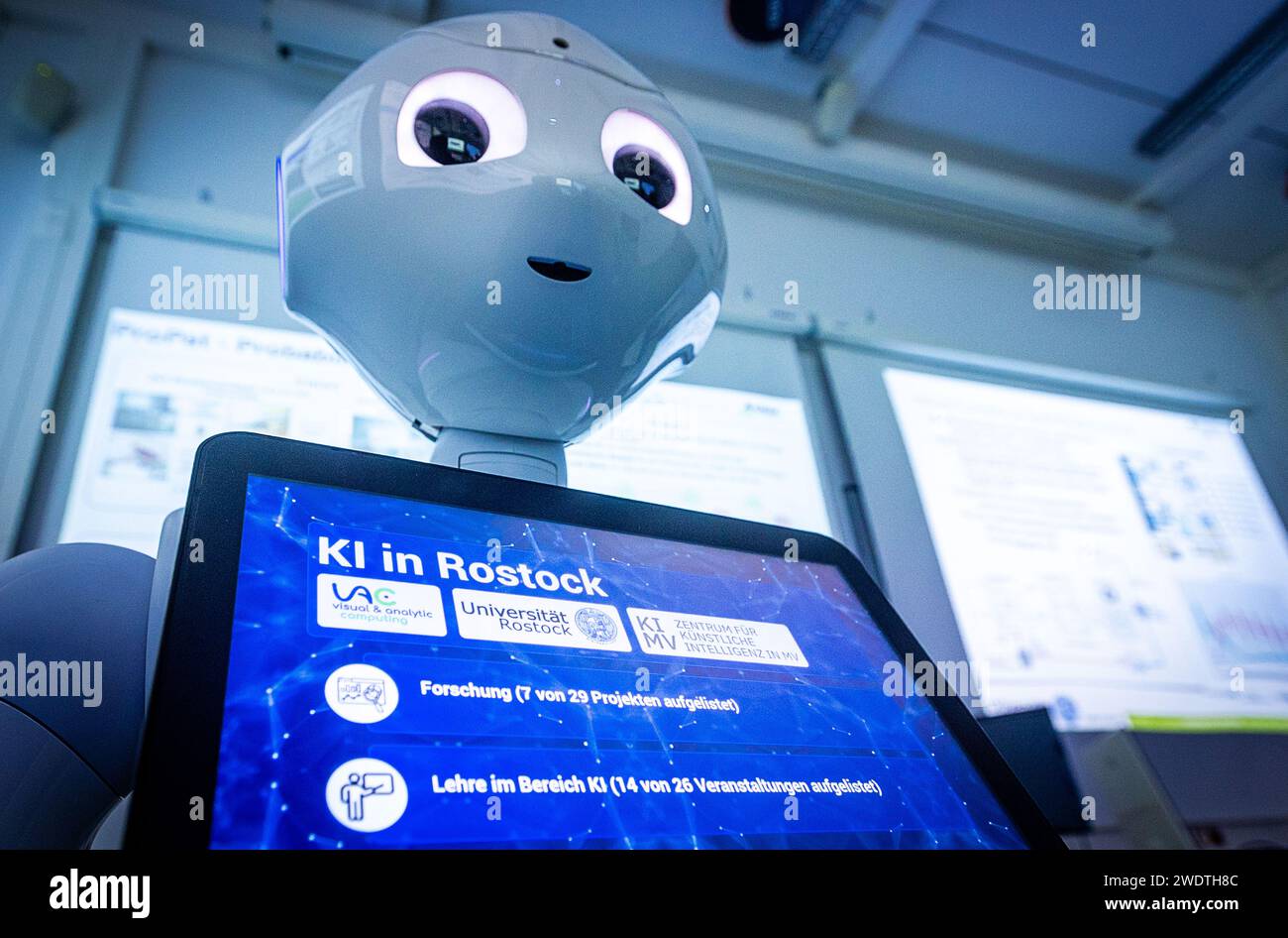 Rostock, Germany. 22nd Jan, 2024. The words 'AI in Rostock' can be read on the display of the Pepper robot. The robot, manufactured by the company Aldebaran Robotics, was programmed by the Rostock scientists for the care of stroke patients. The Minister of Science of Mecklenburg-Vorpommern learned about the current research work during a visit to the Center for Artificial Intelligence (AI) in Mecklenburg-Vorpommern at the University of Rostock. Credit: Jens Büttner/dpa/Alamy Live News Stock Photo