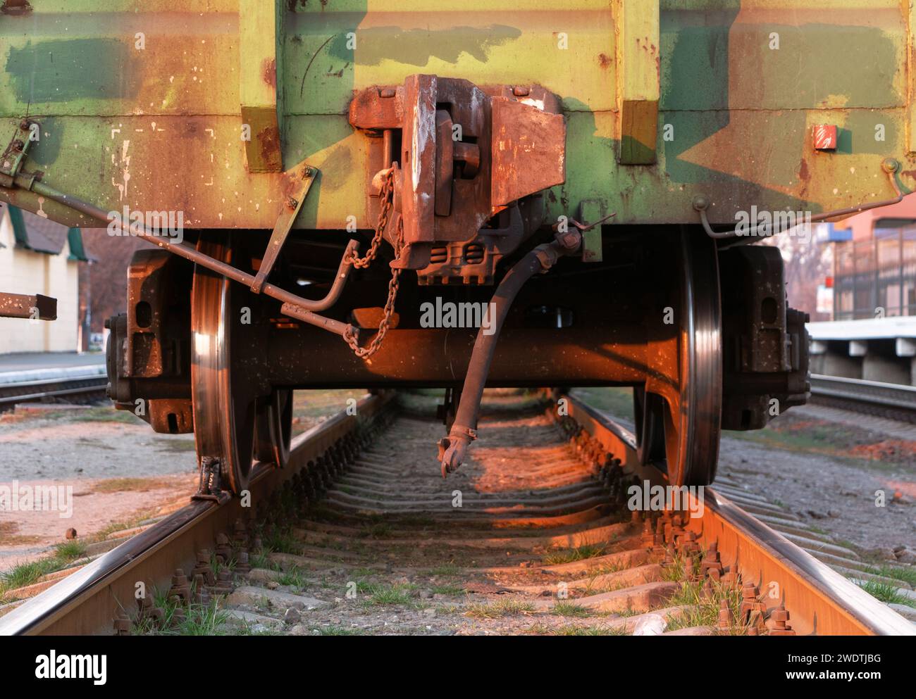 Freight train. Rear view of the last wagon of a freight train at a railway station at sunset. Close-up. Stock Photo