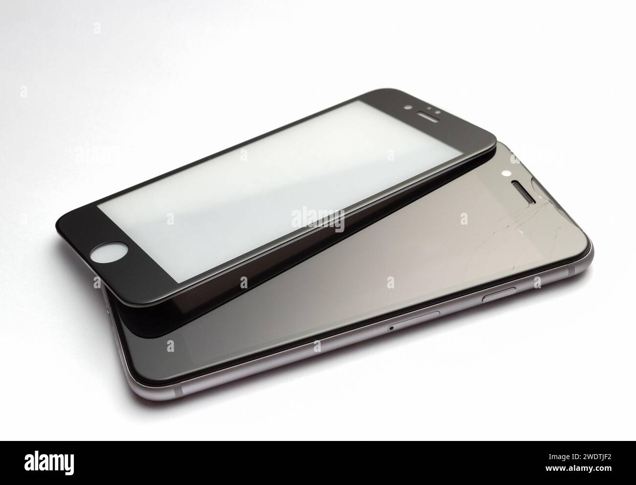 Safety glass for a smartphone with a broken screen on white background. Stock Photo