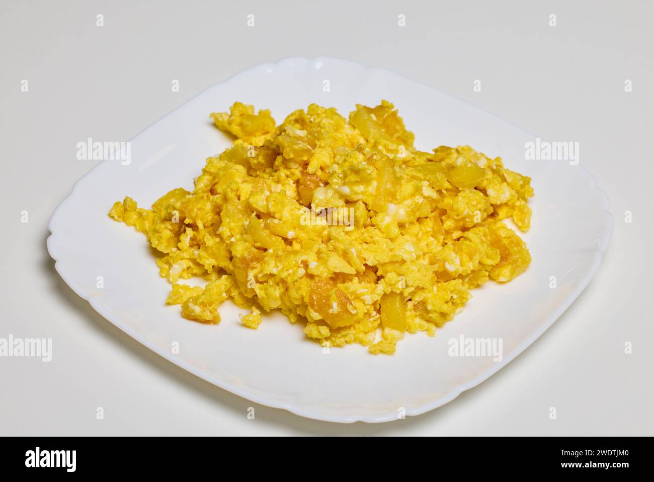 a plate of scrambled eggs on a table ready to be eaten Stock Photo - Alamy