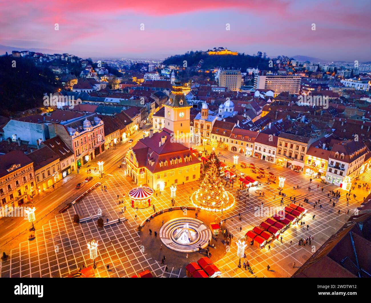 Brasov, Romania. Twilight illuminated Brasov Christmas Market, aerial drone view in historical Transylvania. Stock Photo