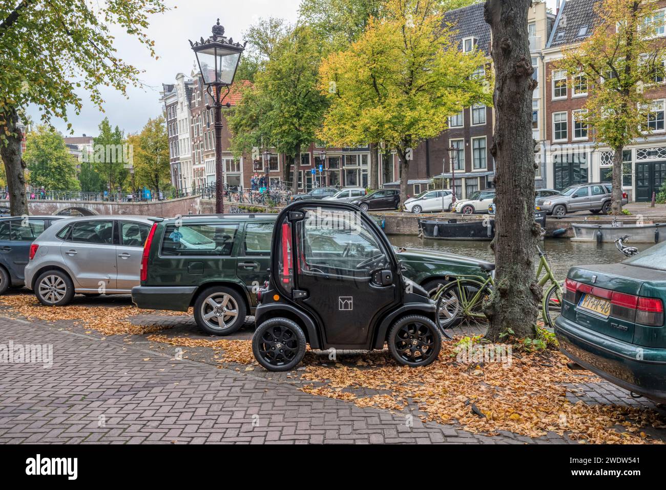 Estrima Biro electric microcar parked beside the Keizergracht canal in Amsterdam. Stock Photo