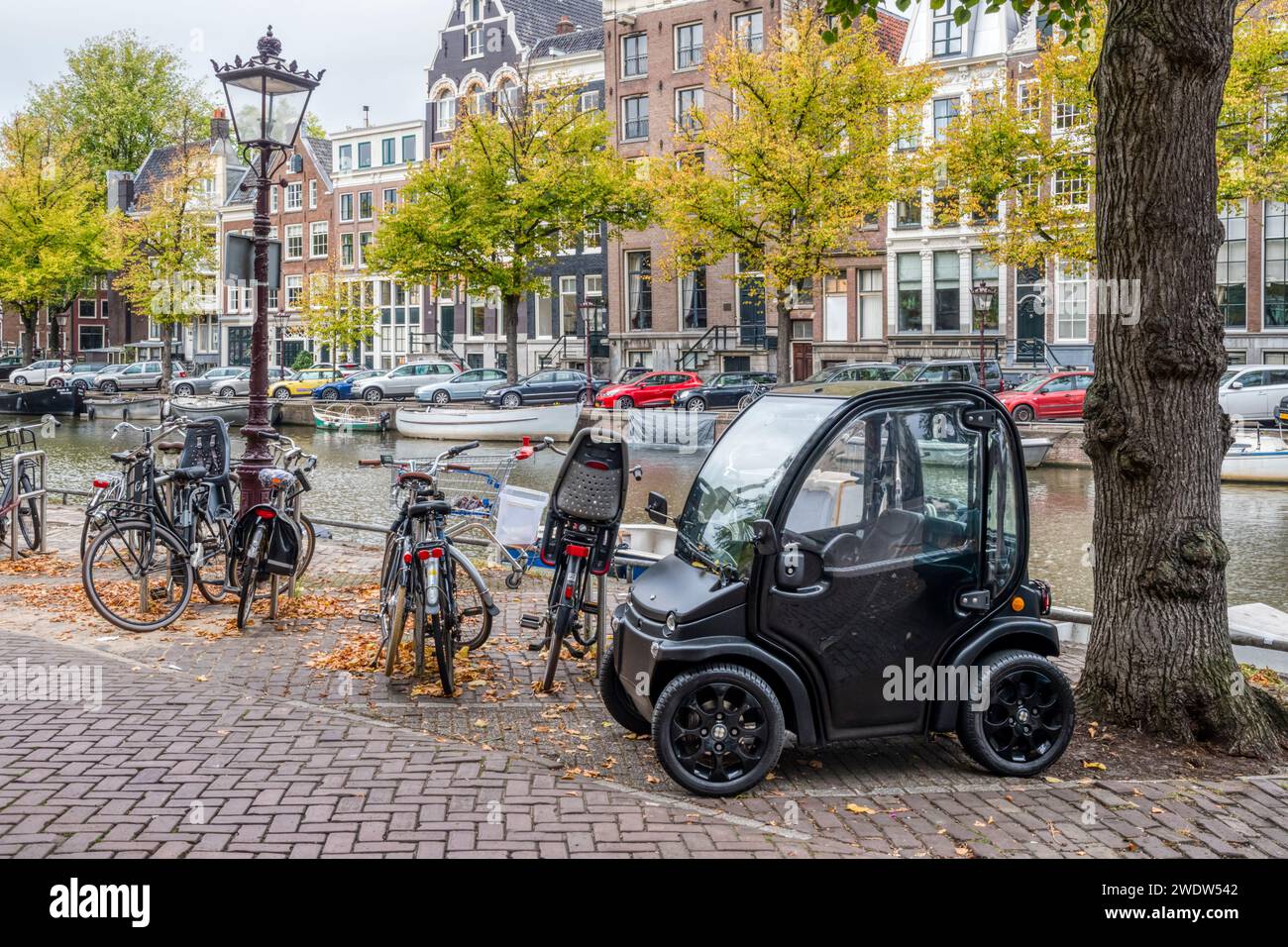 Estrima Biro electric microcar parked beside the Keizergracht canal in Amsterdam. Stock Photo