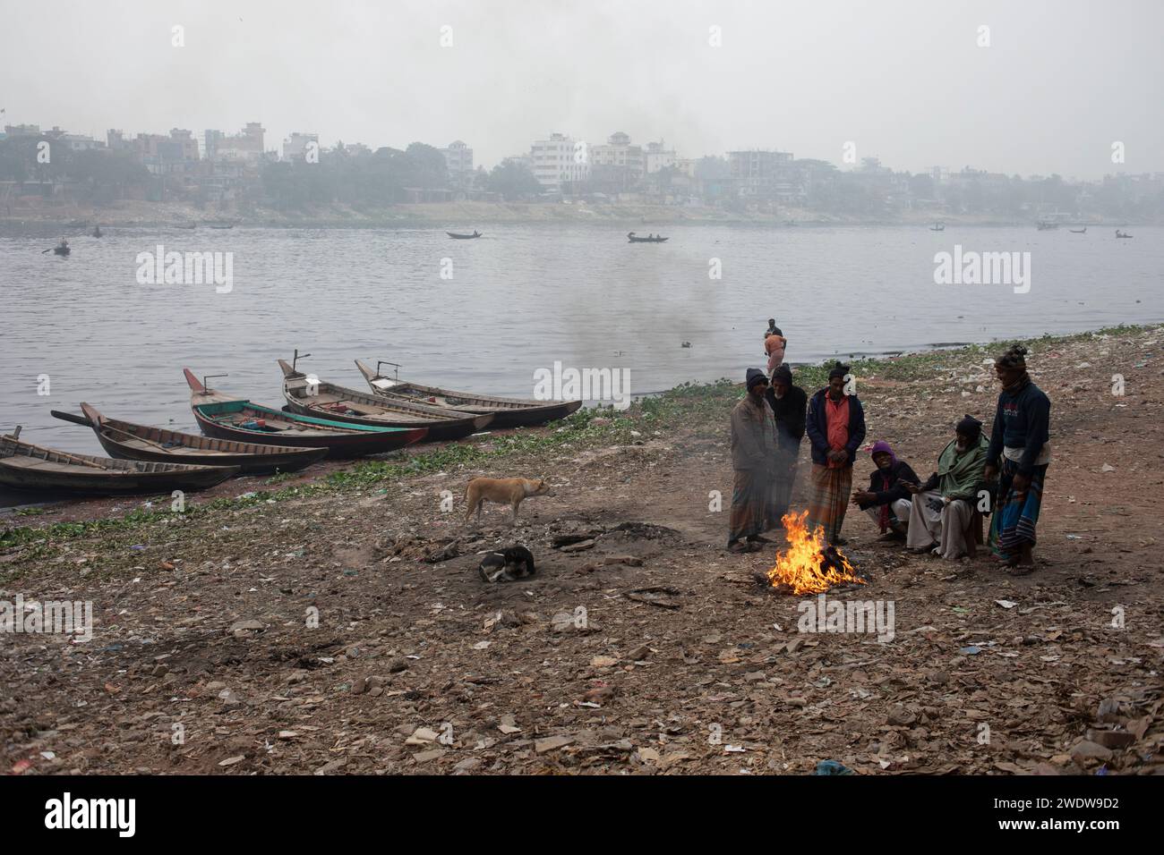 Dhaka, Bangladesh. 22nd Jan, 2024. Workers surround a bonfire for