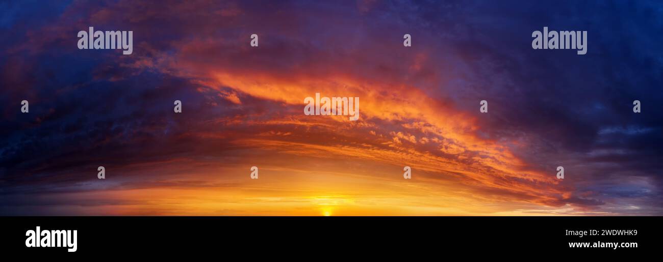 Dramatic sunset sky background with dark clouds. Sky panorama. Stock Photo