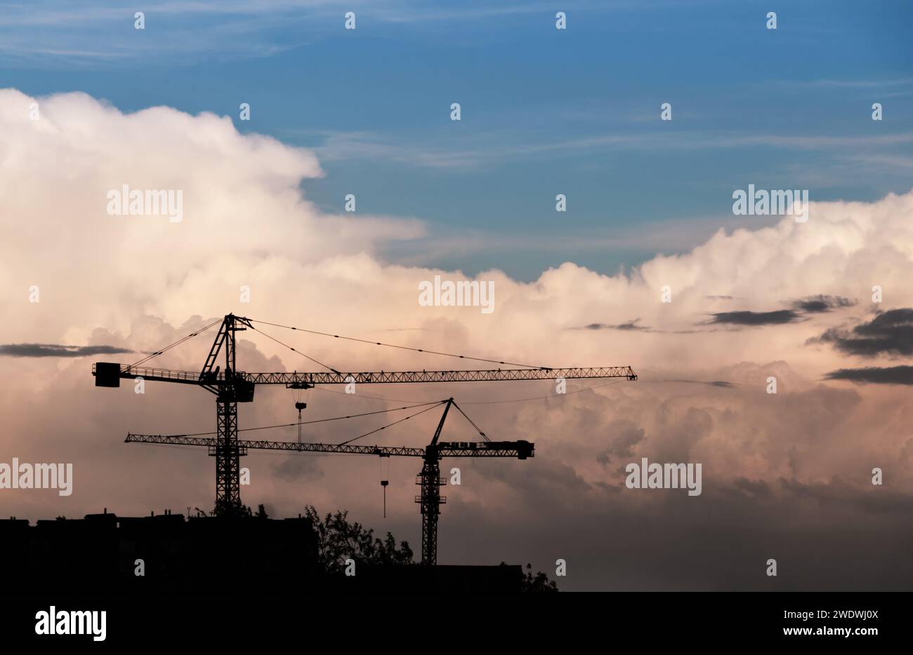 Construction cranes silhouette against the sky with big clouds Stock ...