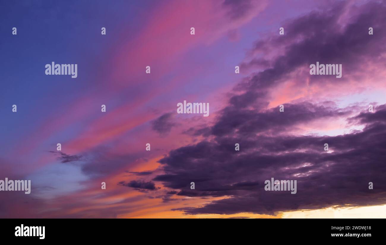 Dramatic sunset sky with clouds during golden hour. Stock Photo