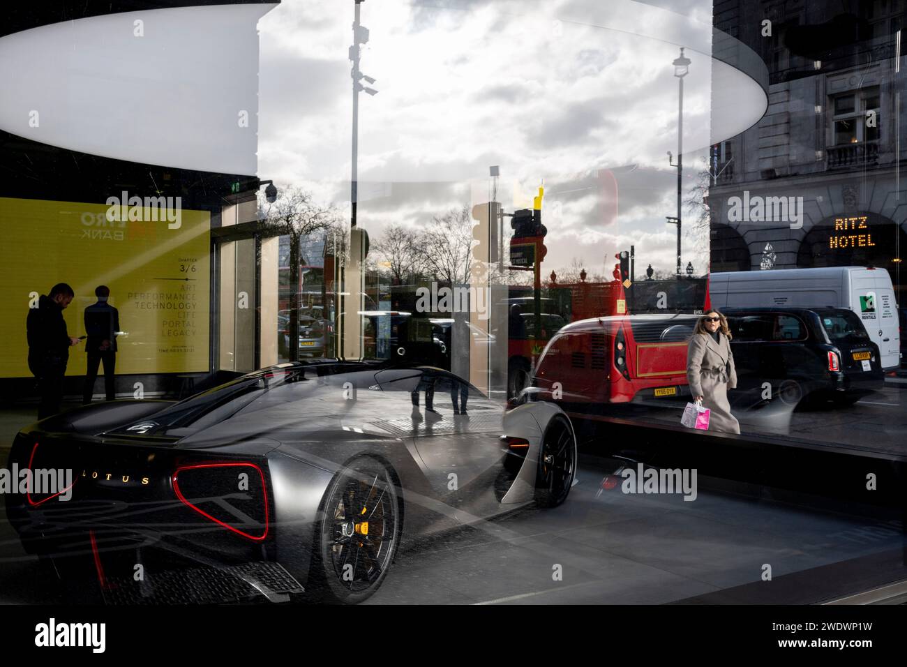 Pedestrians pass-by a Lotus sports car which is positioned in the window of the British motoring brand's showroom on Piccadilly, on 22nd January 2024, in London, England. Stock Photo