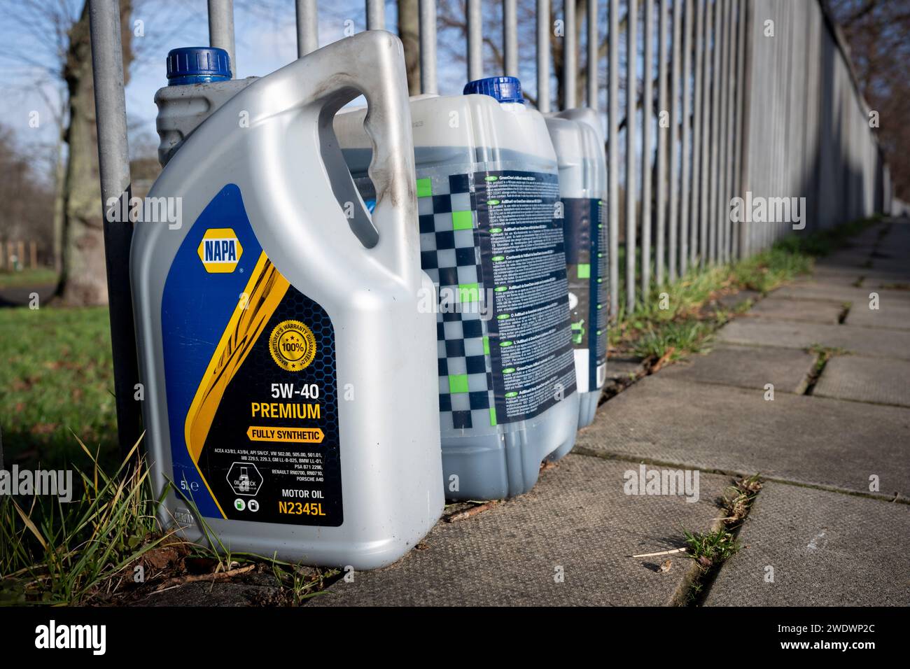 Five-litre plastic containers of NAPA motor oil has been dumped on the pavement by the railings of Ruskin Park in Lambeth, on 22nd January 2024, in London, England. Stock Photo