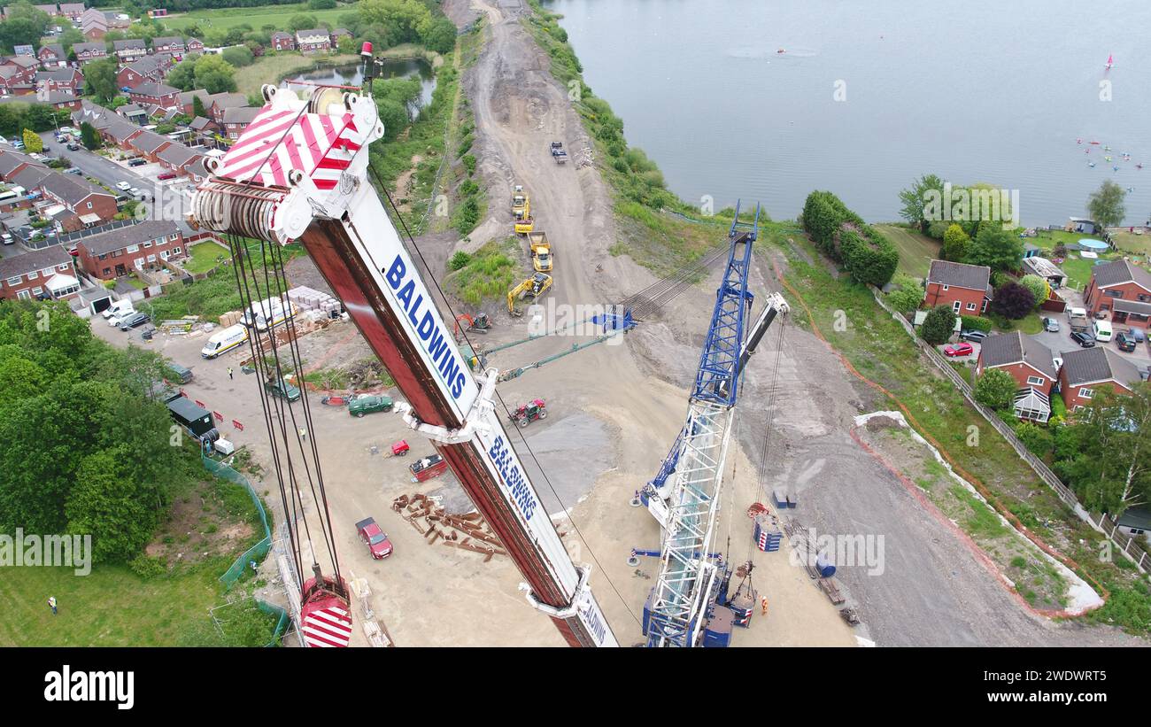 Aerial photography of a heavy Baldwins crane lifting bridge beams into place over Poolstock Lane