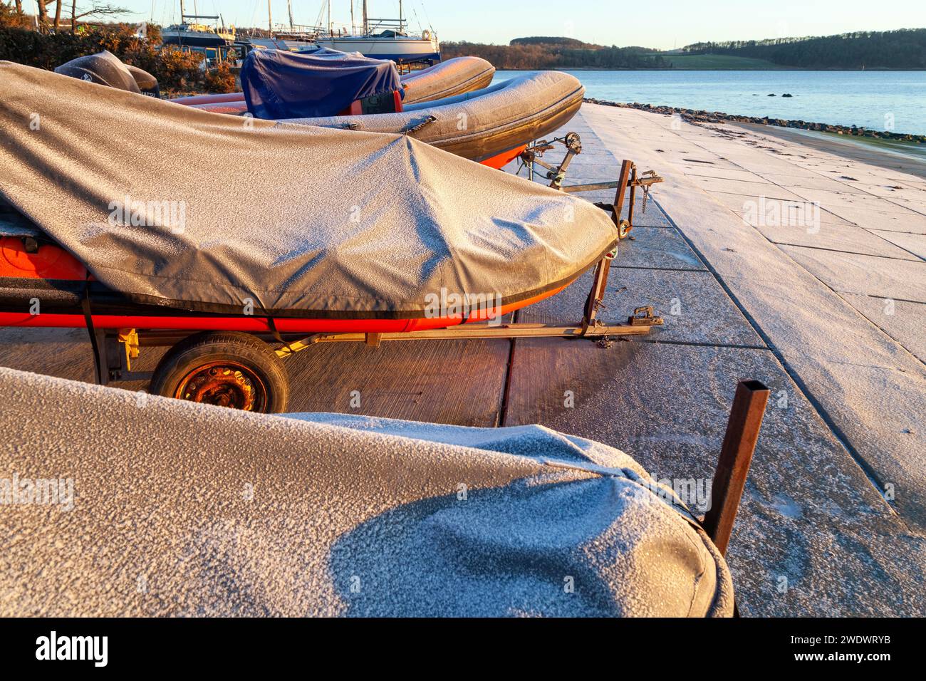 inflatable ribs out of the water in a boat yard covered with a ...