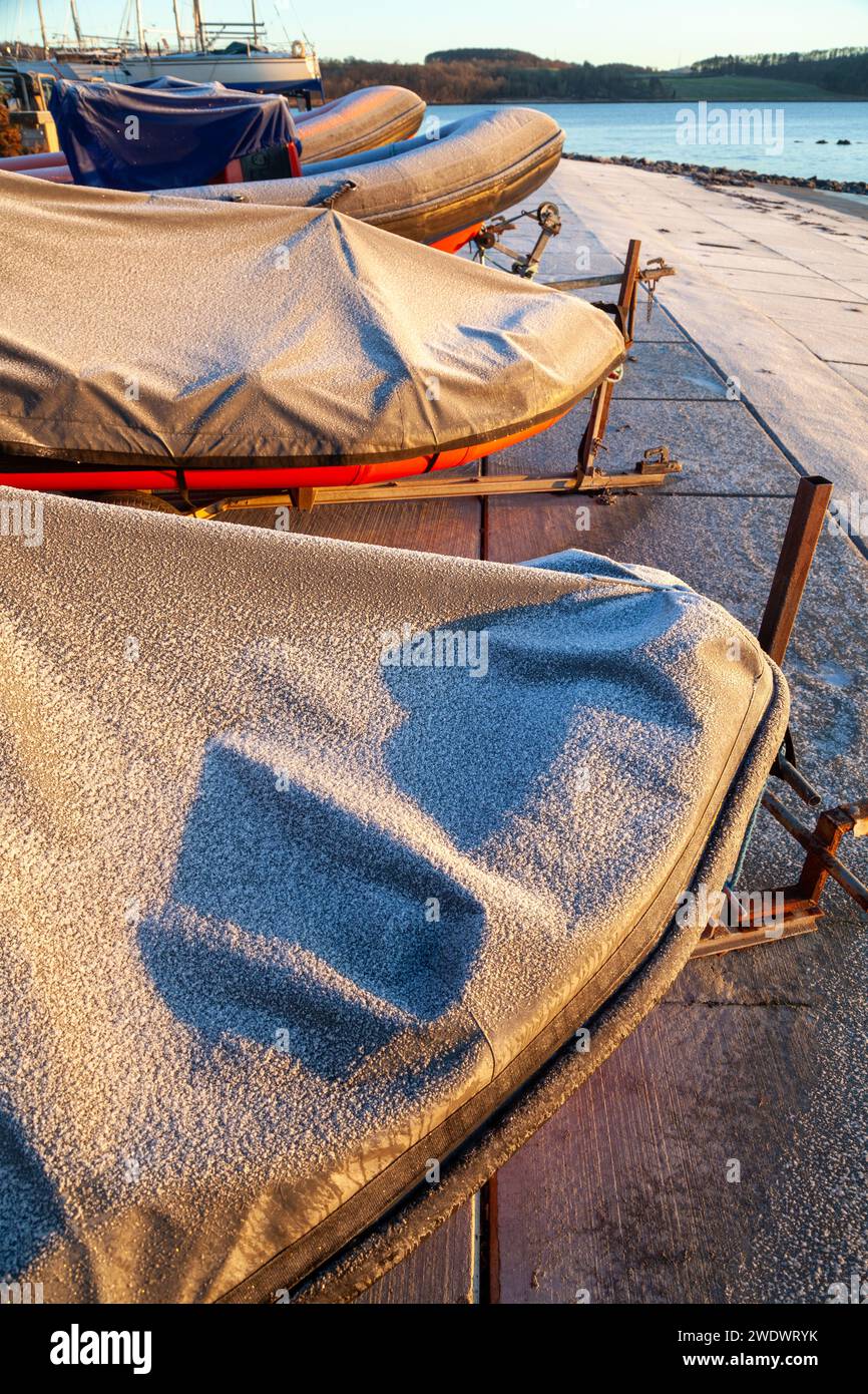 inflatable ribs out of the water in a boat yard covered with a ...