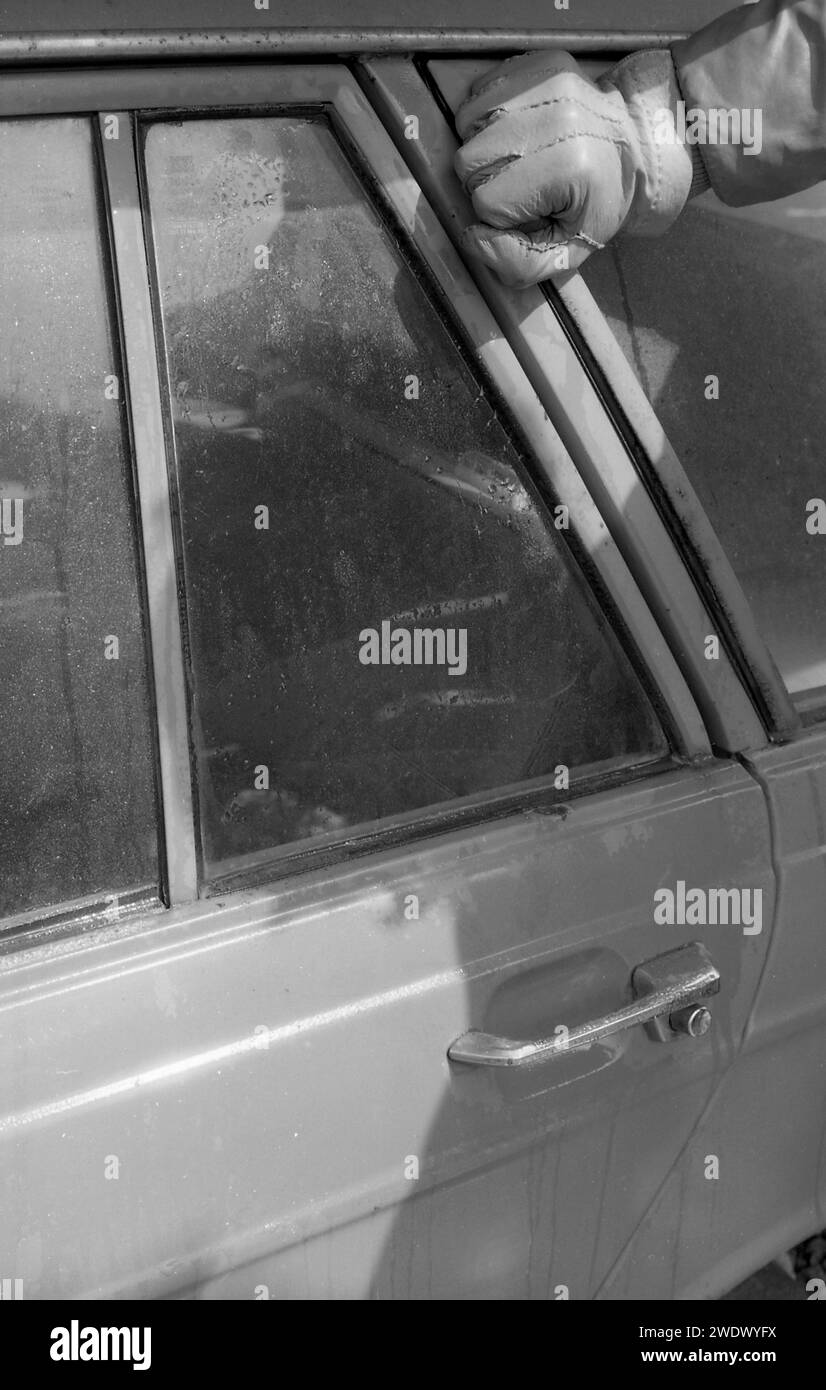 1970s, historical, breaking a car window using a hammer, possibly Ford