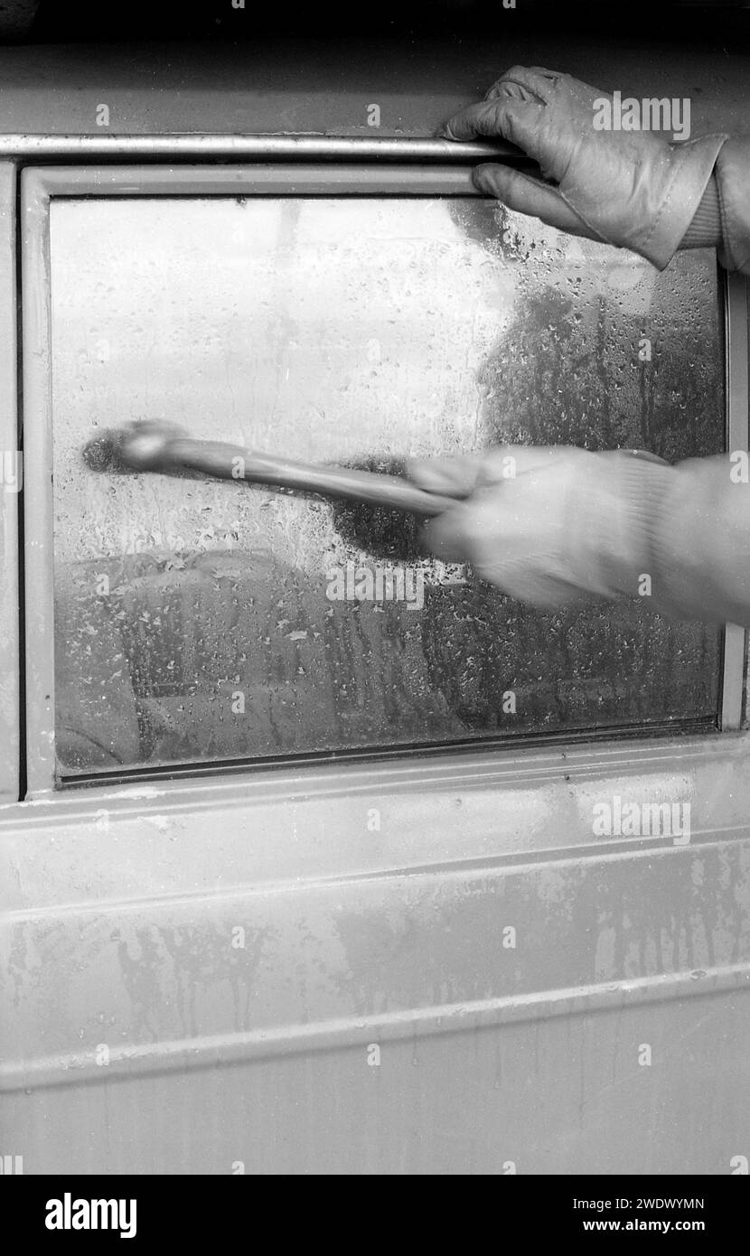 1970s, historical, a thief breaking a car window, a back vent window of