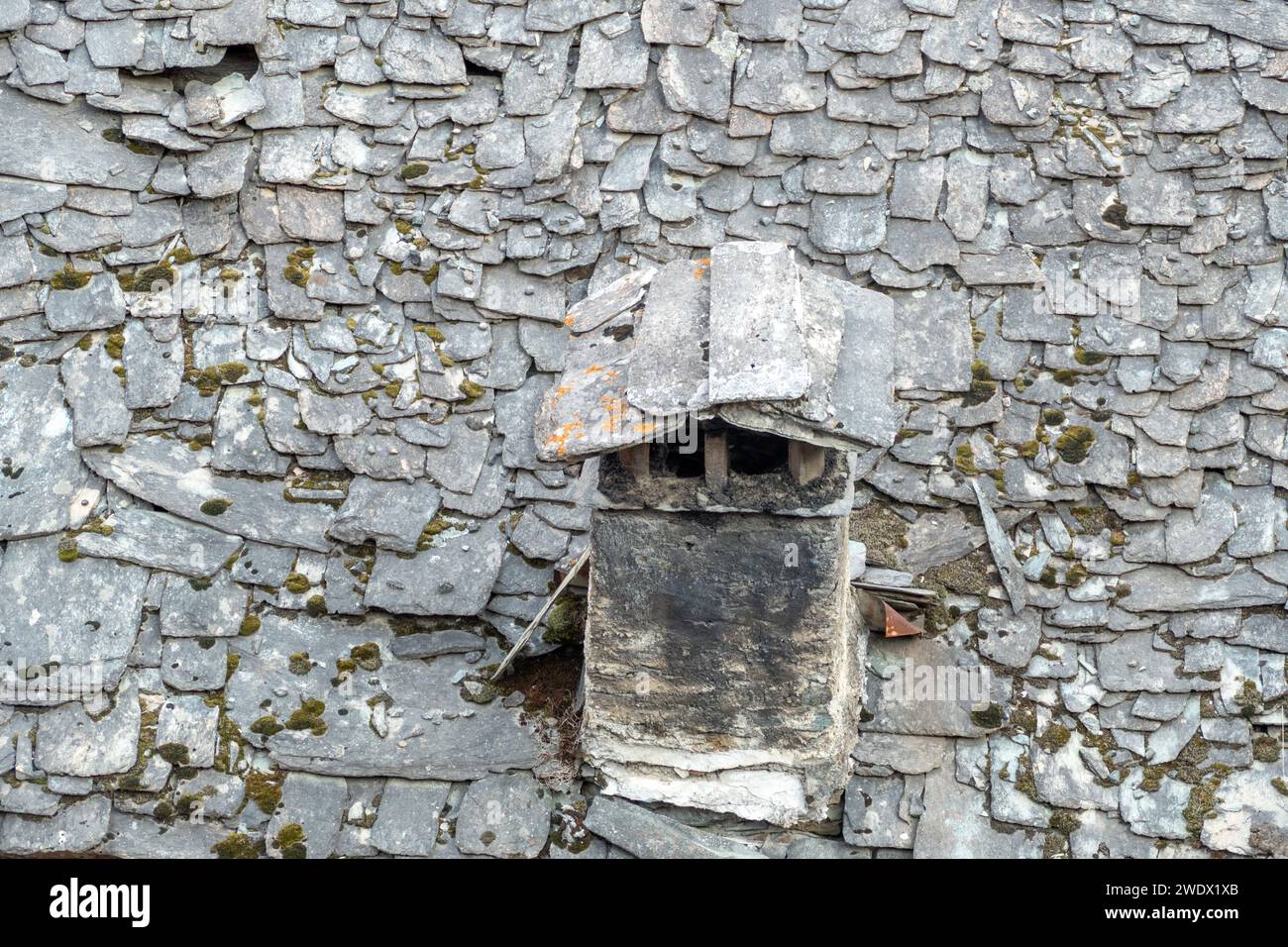 old chimney at a house with old slate roof in Caspoggio in Region Valmalenco, Italy Stock Photo