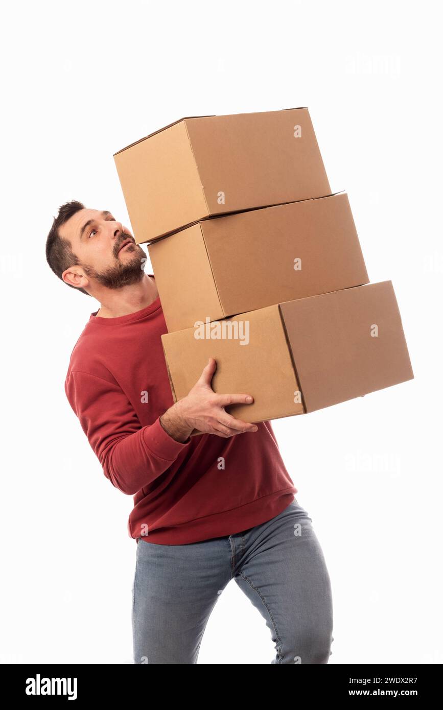 Man with red sweater and white background holding boxes and trying not to drop them. Help for home delivery. Solution for moving problems. Shipping se Stock Photo