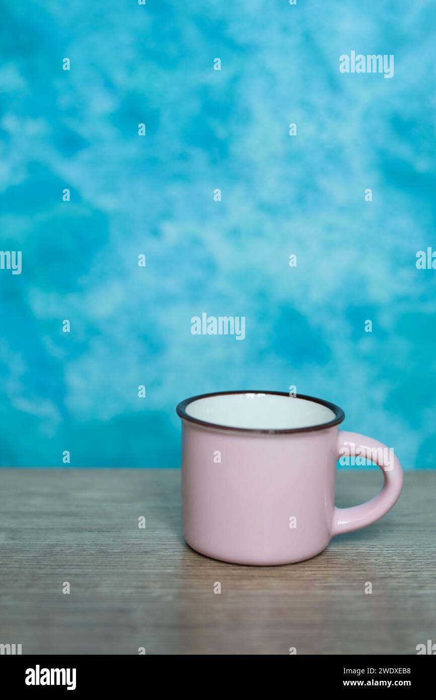 pink mug on a blue background. Minimalism. Stock Photo