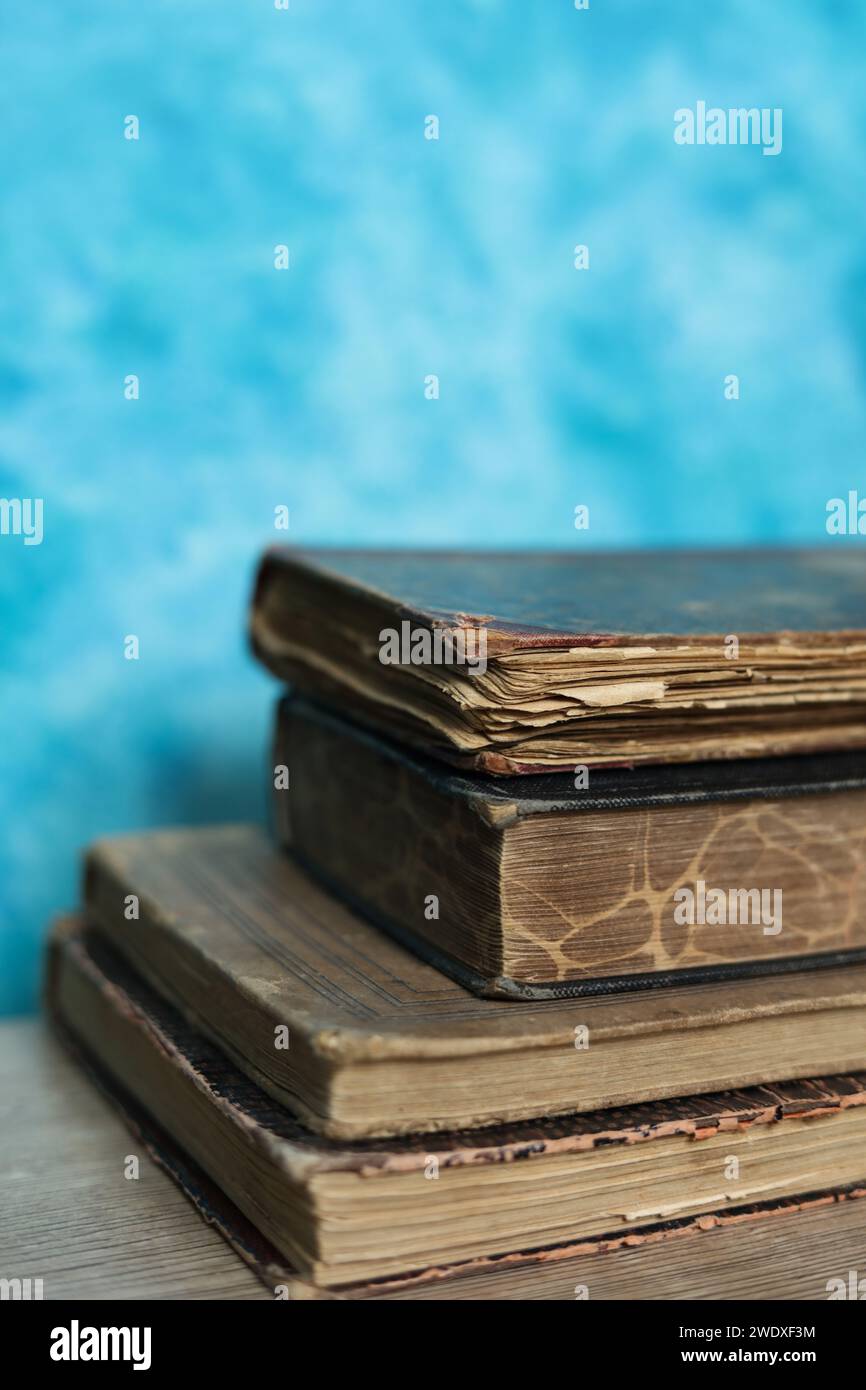 Stack of old books on a wooden table with blue wall background Stock ...