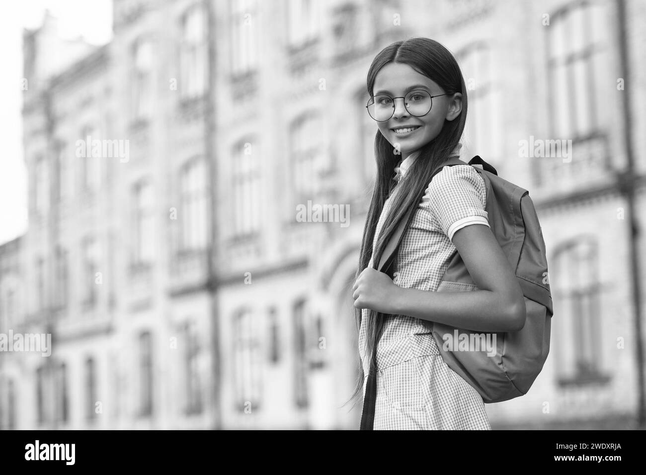 smiling teenage school brunette girl, copy space. teenage school girl with backpack. Stock Photo