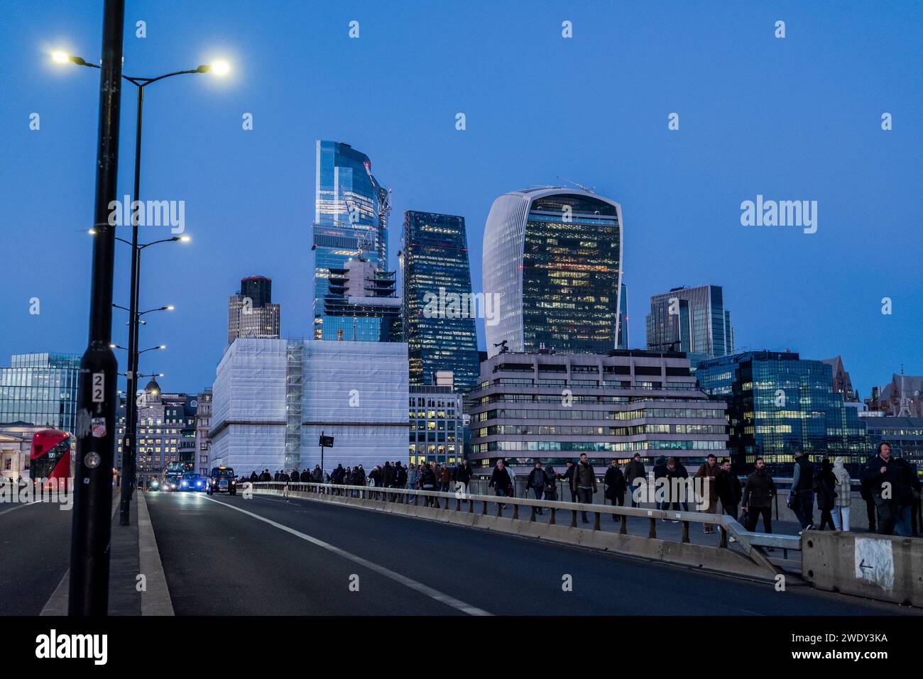 People walking over London Bridge and Cityscape of the City of London with the Walkie-Talkie and Cheesegrater towers,  London, England, UK Stock Photo