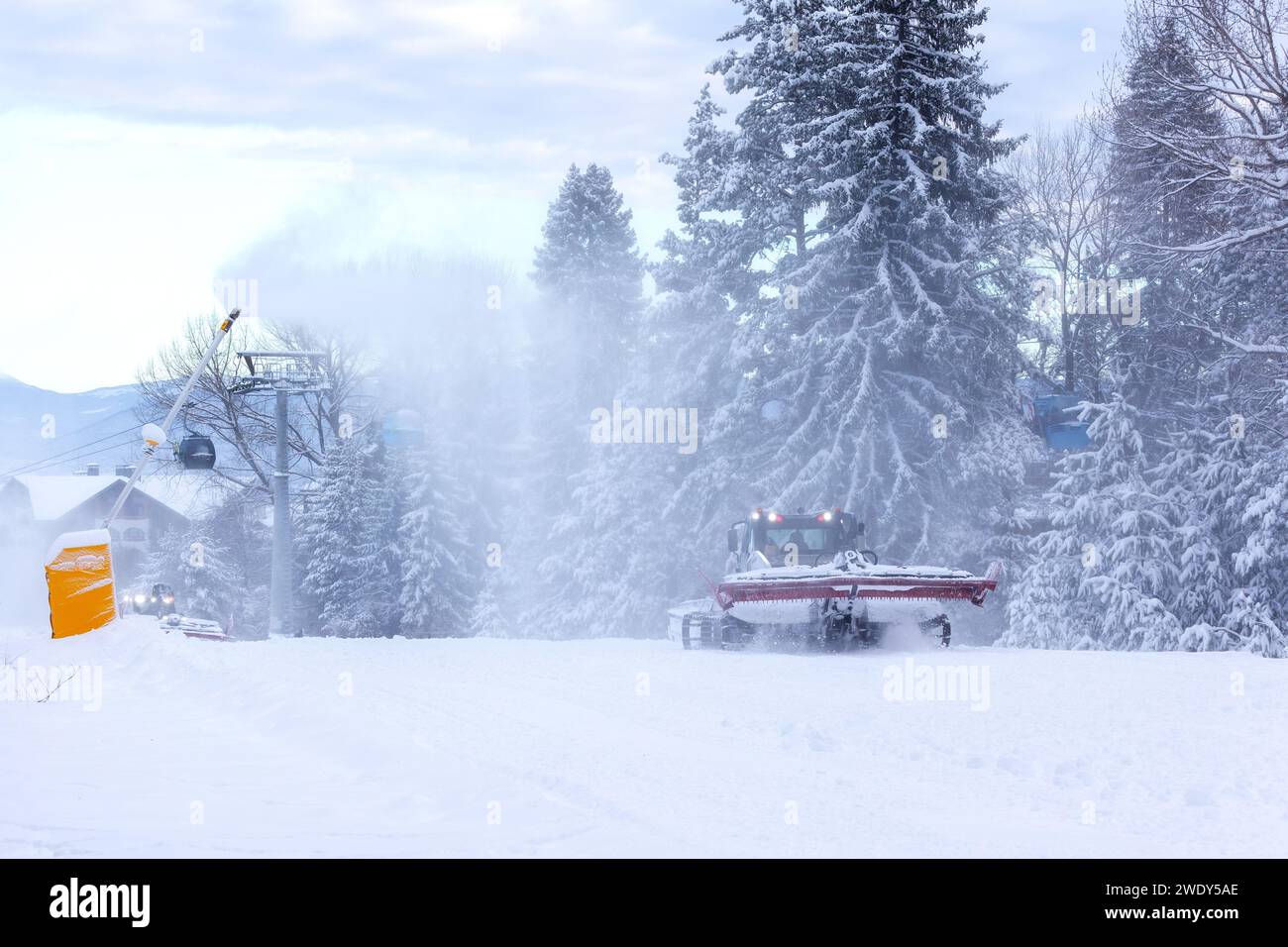 Snow groomer snowcat ratrack machine preparing ski road slope for alpine skiing, winter resort Bansko, Bulgaria Stock Photo