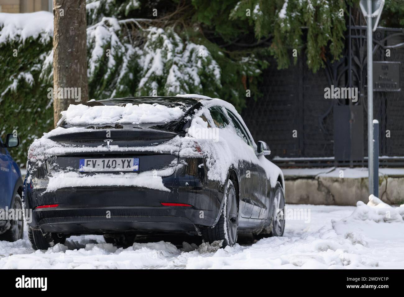 Nancy, France - Black Tesla Model 3 parked on the street with snow. Stock Photo