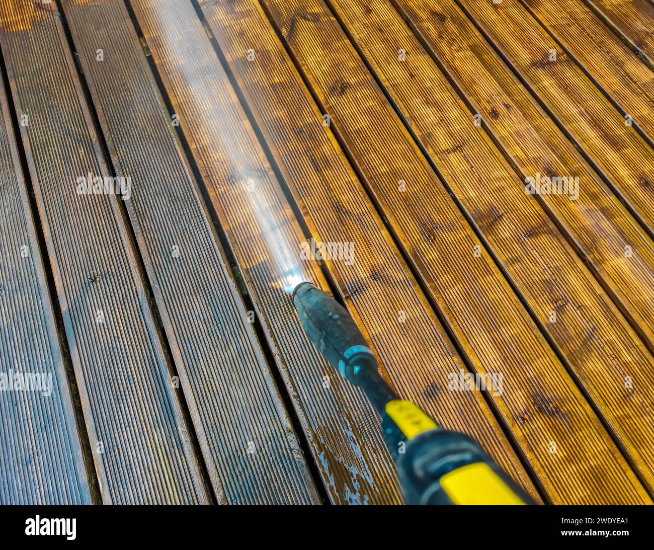 Cleaning wooden terrace decking before oiling and painting with a high pressure water cleaner