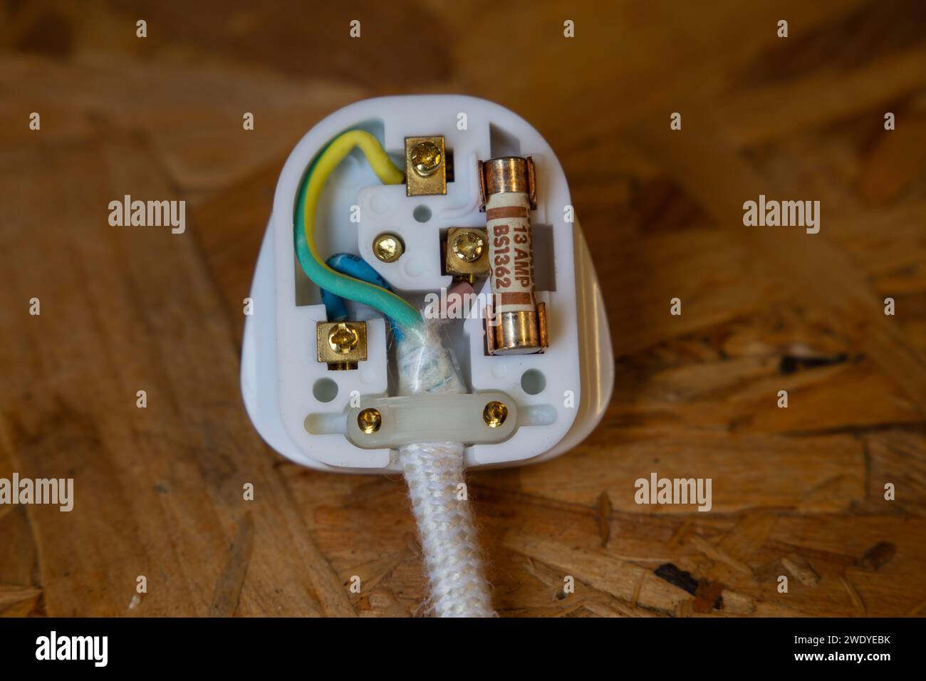 Close-up of a UK 3 pin mains electrical plug showing the wire colours and 13 amp fuse Stock Photo