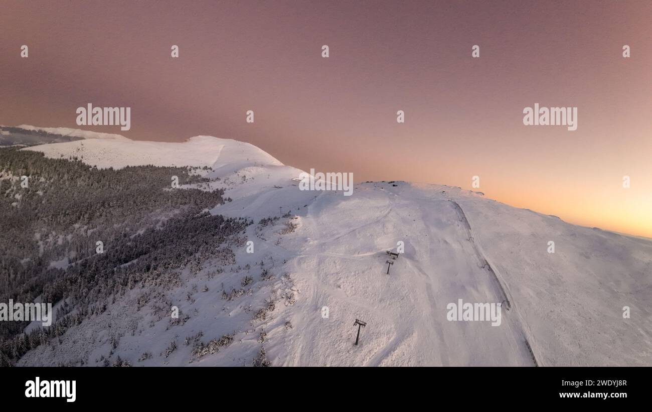 a ski slope in a valley covered in snow at sunset, Straja Romania Stock Photo