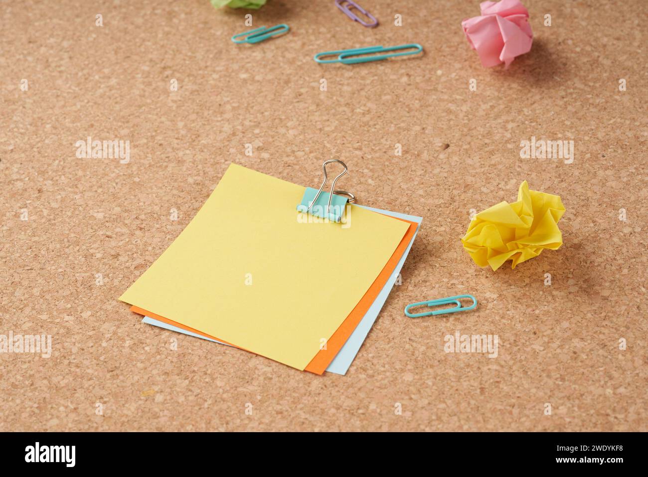 Several multi-colored sheets paper fastened with a paper clip. Stock Photo