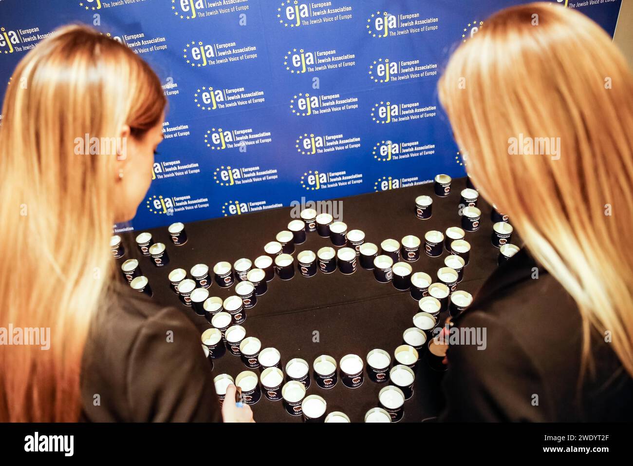 Krakow, Poland. 22nd Jan, 2024. Women light Jewish start shaped candle