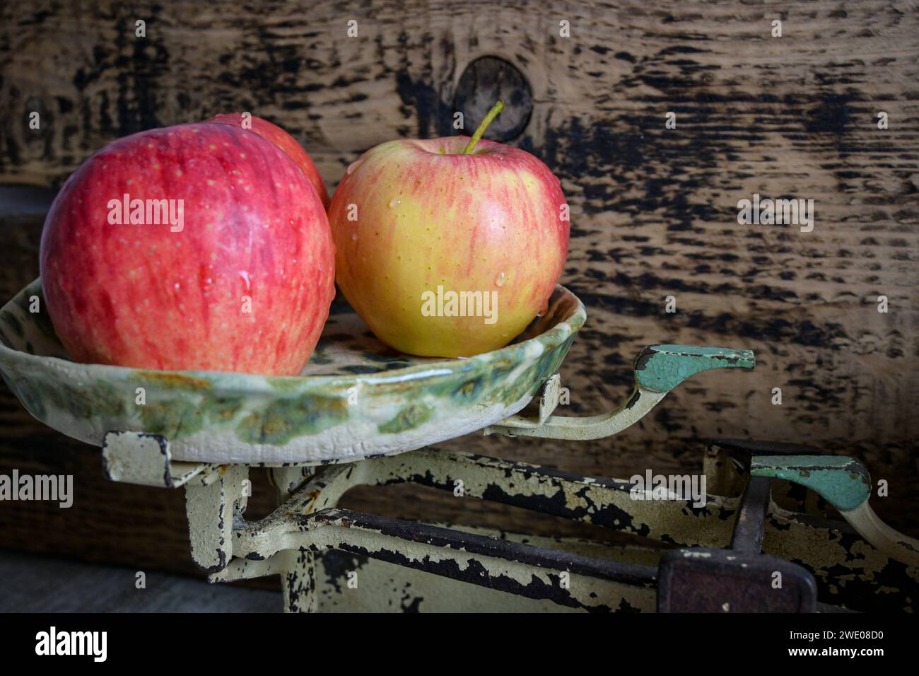 red apple on a scale and wooden background, retro style - side view. Stock Photo