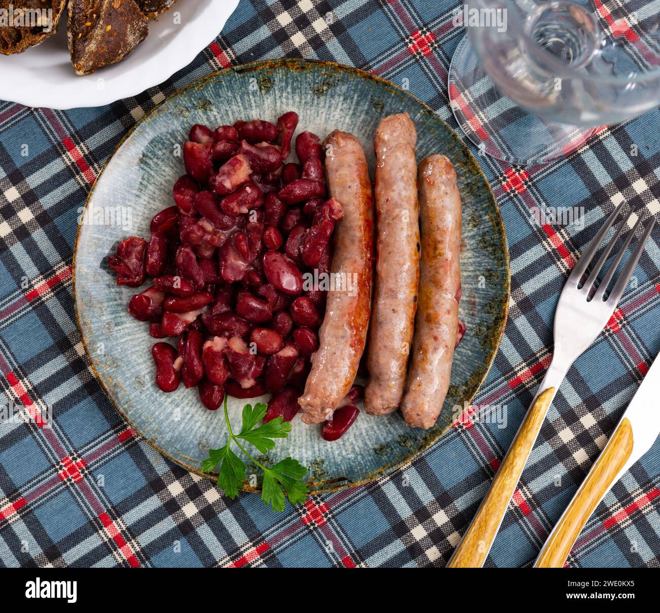 Traditional Catalan dish of fried pork sausage Butifarra with side dish ...