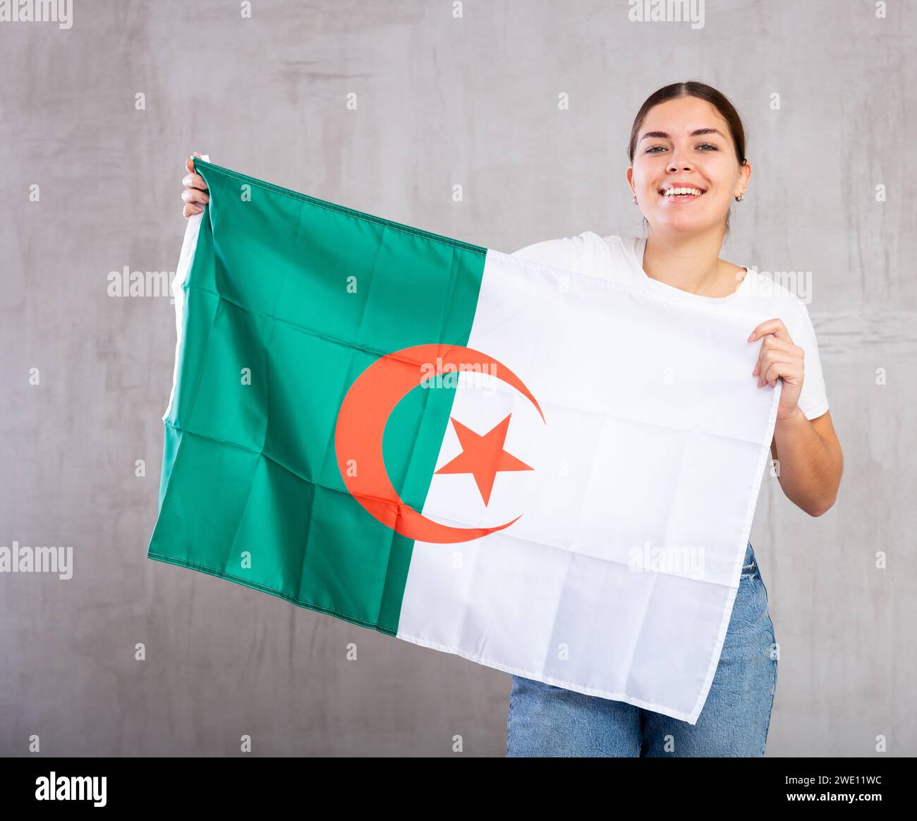 Portrait of positive young woman holding Algeria flag Stock Photo