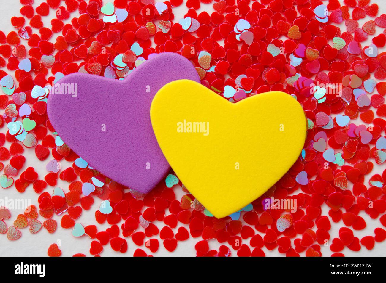 Pair of purple and yellow hearts on group of small hearts Stock Photo