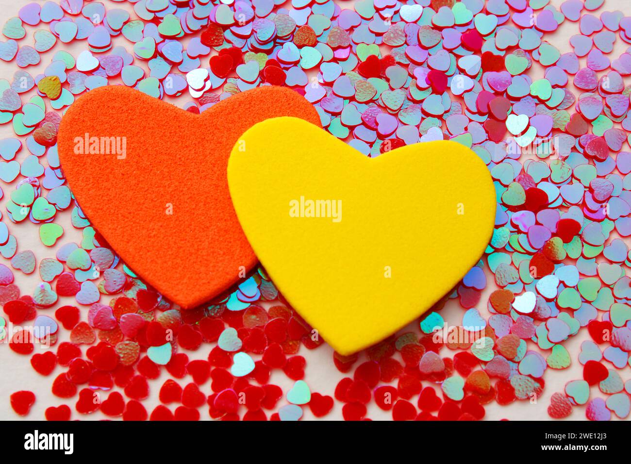 Pair of orange and yellow hearts on group of small hearts Stock Photo