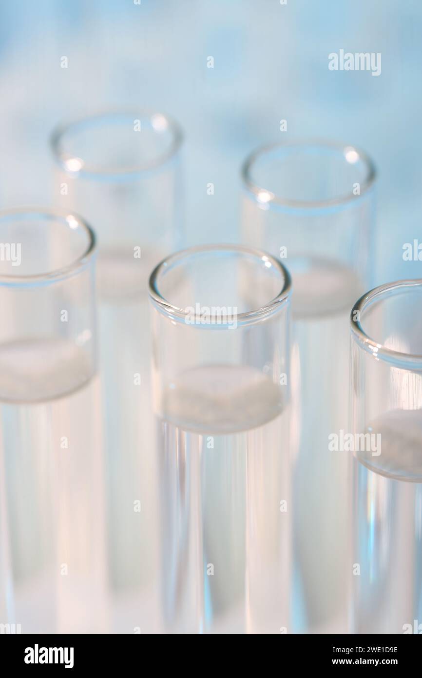 Laboratory analysis. Many glass test tubes on light blue background ...