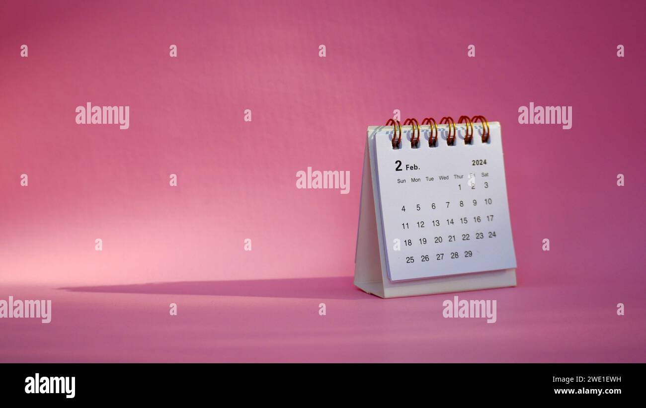 Desk calendar for February 2024 on a pink background with copy space ...