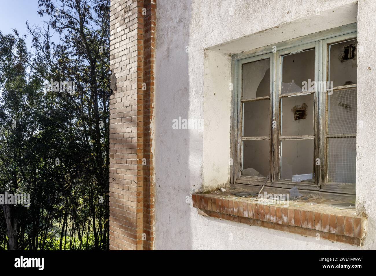 An old, rickety window with broken glass in an old, abandoned building Stock Photo