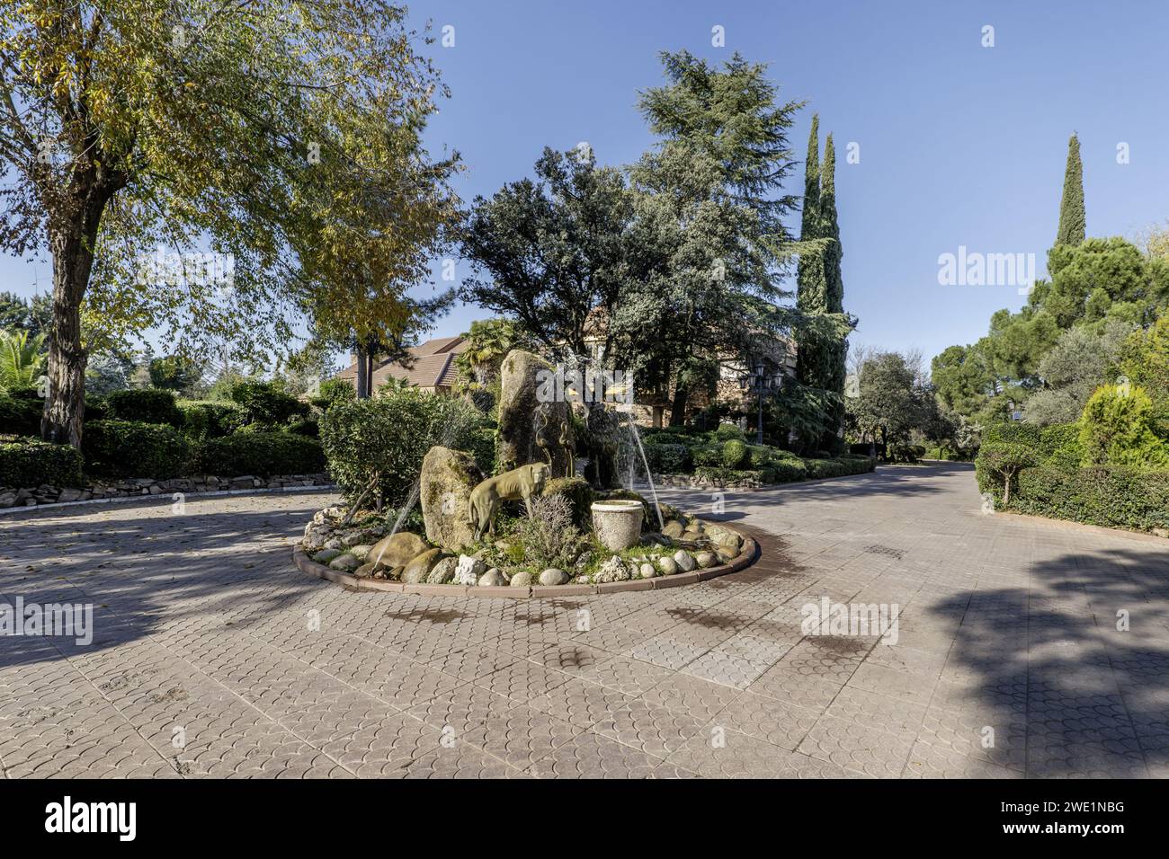 A fountain in the gazebo of a paved walk within an extensive property with a single-family home Stock Photo