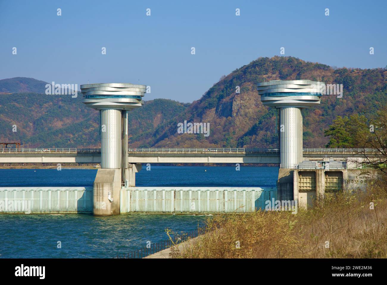 Sangju City, South Korea - November 18th, 2023: A detailed view of two of the Sangju Weir's iconic towers, with a rugged mountain face providing a dra Stock Photo