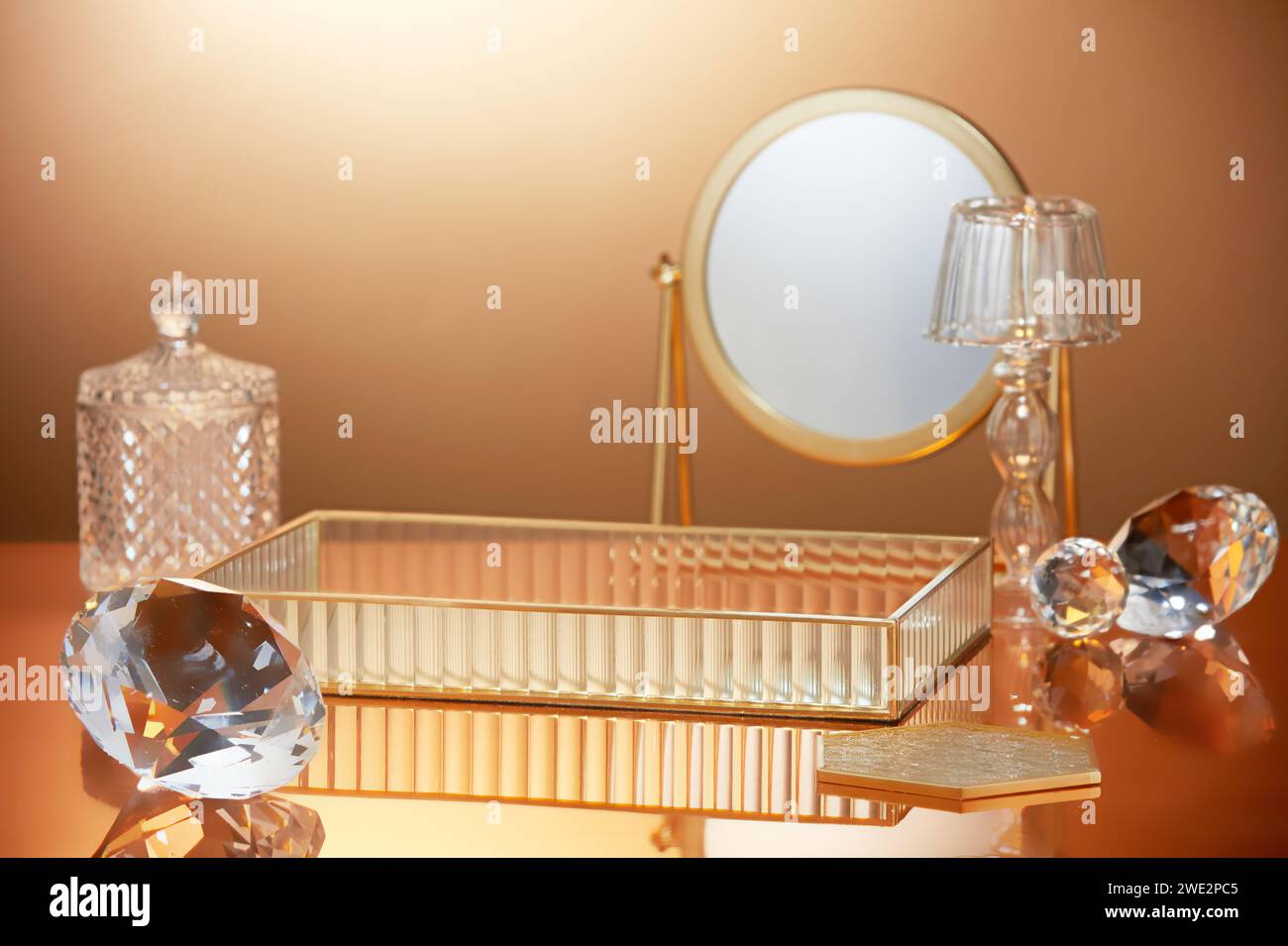 Scene to advertising and branding products with luxury concept. Diamonds, round mirror and tray decorated in backlit gold background. Space for design Stock Photo
