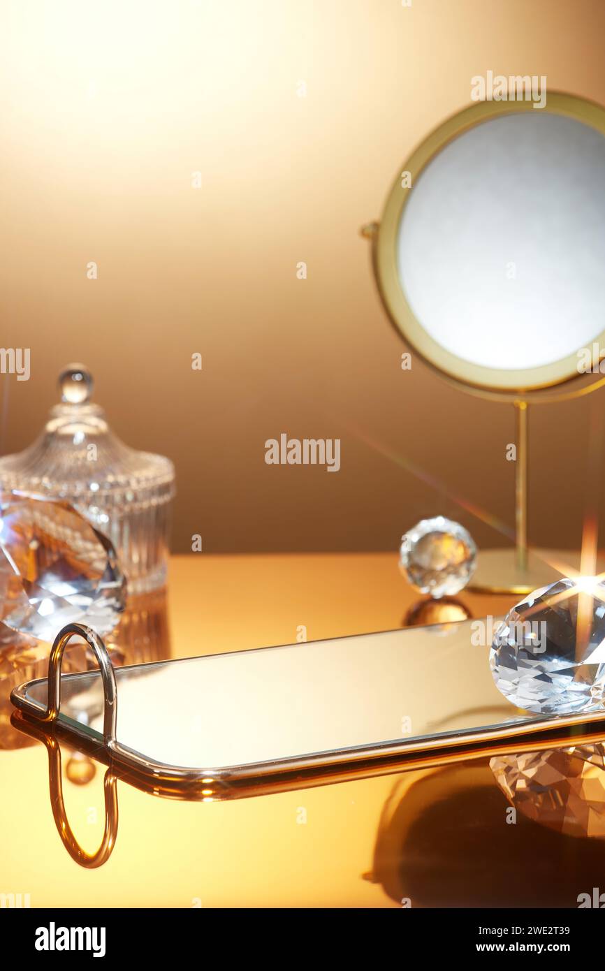 On a luxurious gold background, glittering objects are decorated with mirrors and empty trays. Blank space for cosmetic product presentation. Scene fo Stock Photo