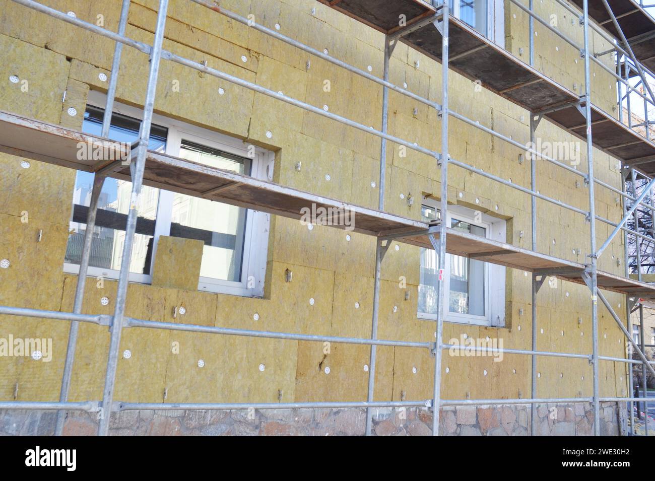 Installing mineral wool insulation over exterior wall for home energy