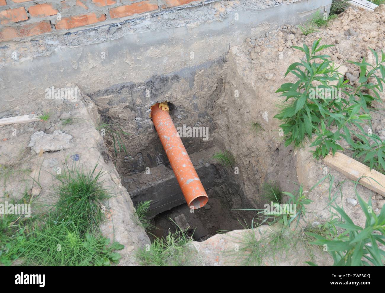 Sanitary Sewer Pipe in the House Foundation  Wall. Sewer pipe  in dirt hole during house sewer system construction. Stock Photo