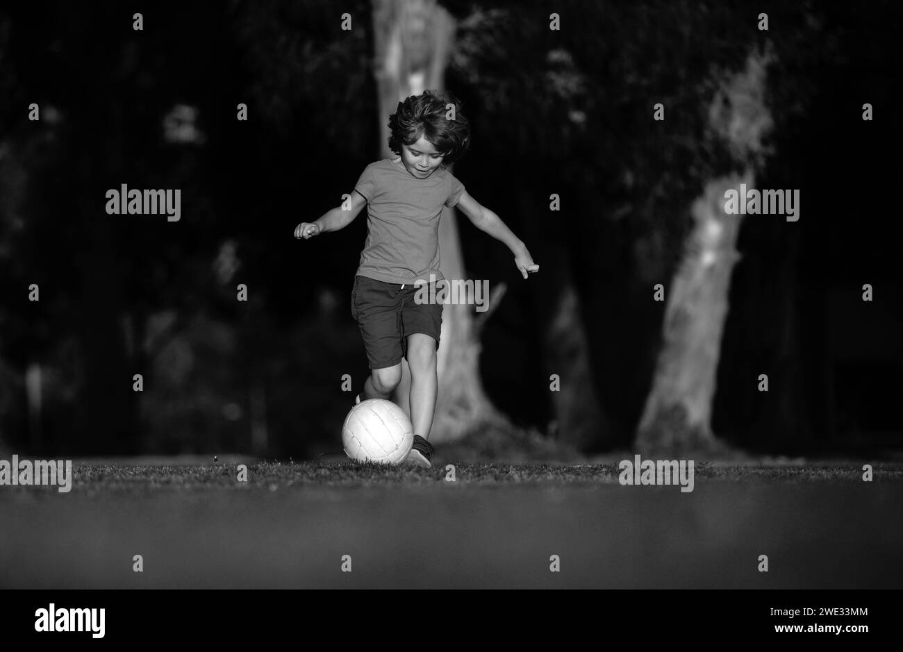 Soccer kid. Kids play football on outdoor stadium field. Little boy
