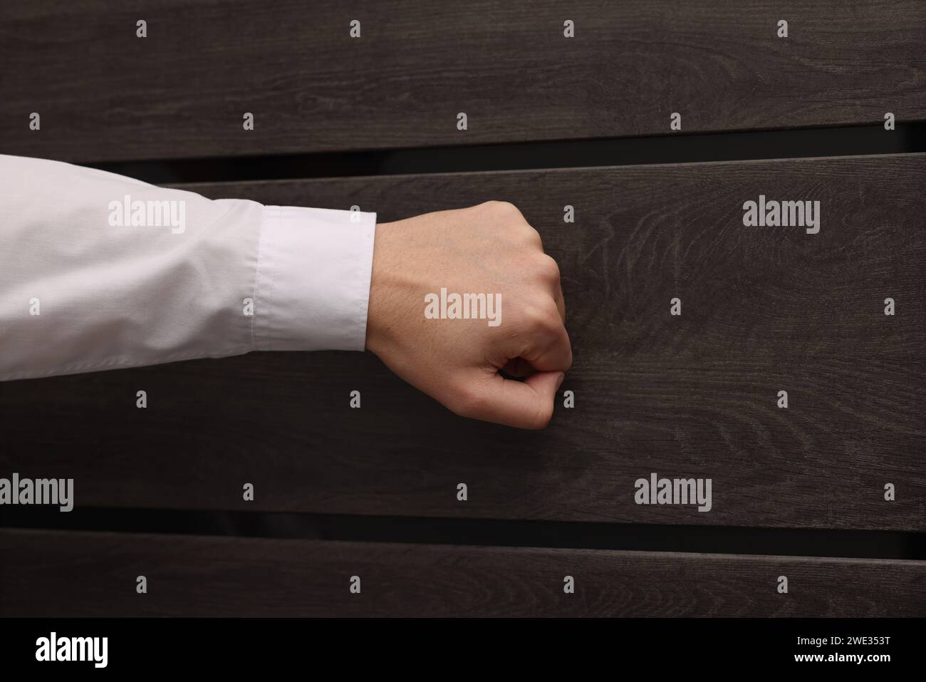 Collector knocking on door indoors, closeup view Stock Photo