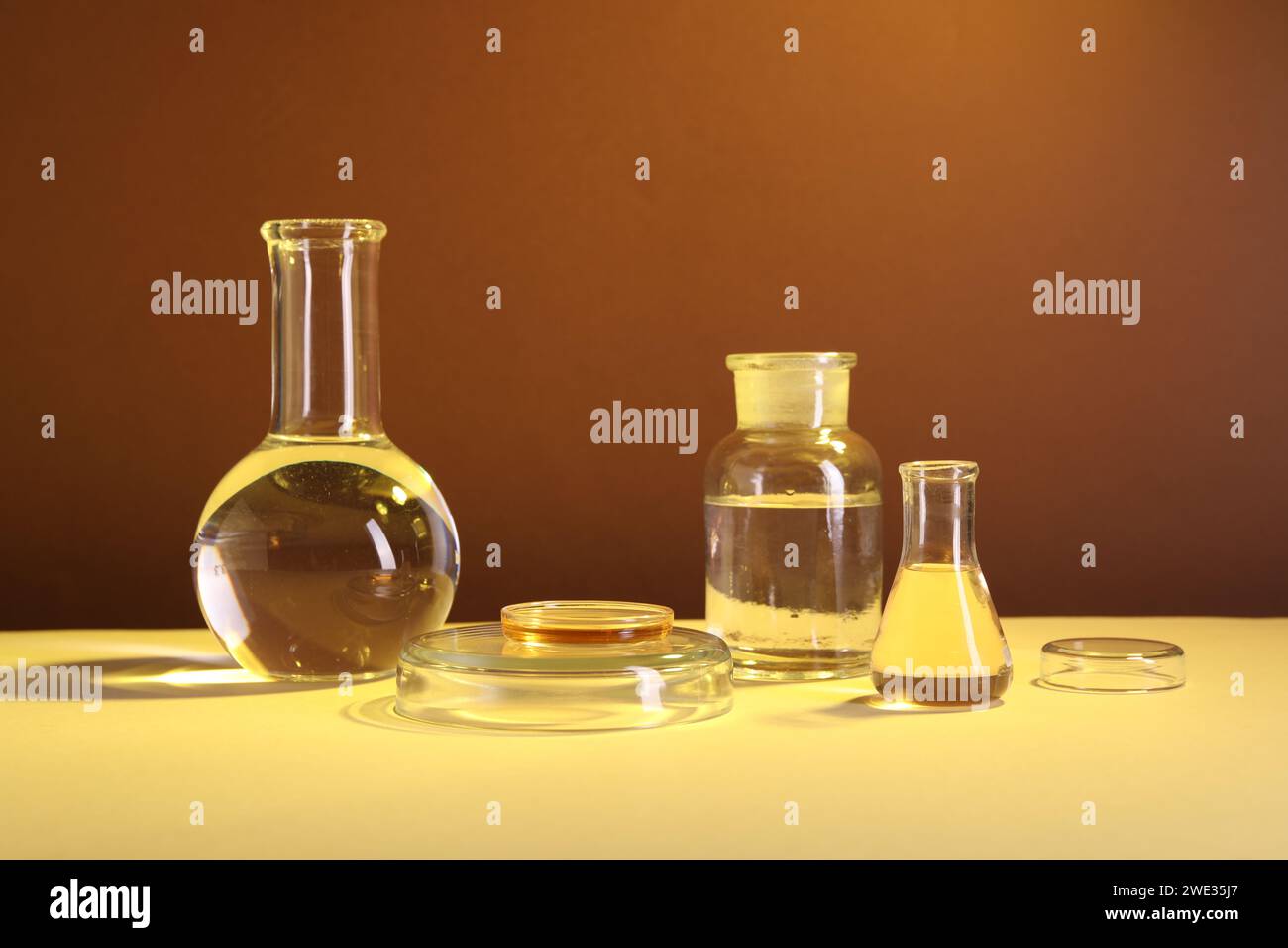 Laboratory analysis. Different glassware on table against brown ...